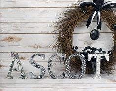 a wreath with the word class spelled out in front of it on a white wooden background