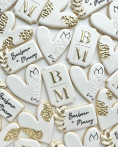 many decorated cookies with names and hearts in gold, white and black colors are arranged together