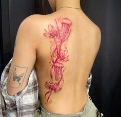 the back of a woman's body with tattoos on it