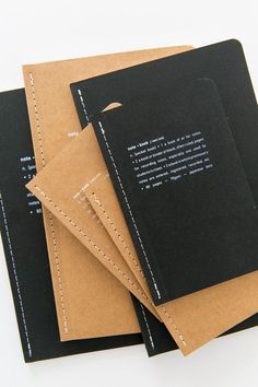 three notebooks stacked on top of each other with stitching at the bottom and inside