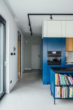 a kitchen with blue cabinets and bookshelves in it