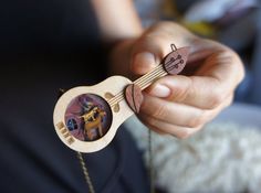 a person holding a small wooden instrument with pictures on it