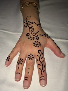 a woman's hand with hennap on it and some black dots in the middle