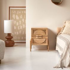 a bed room with a neatly made bed next to a night stand and a mirror