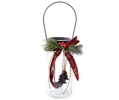 a glass jar with a christmas decoration hanging from it's side and a ribbon around the top