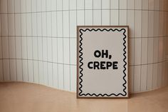 a sign that says oh, crepe on it in front of a tiled wall