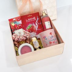 an open box with various items inside on a white tablecloth and pink ribbon tied around it