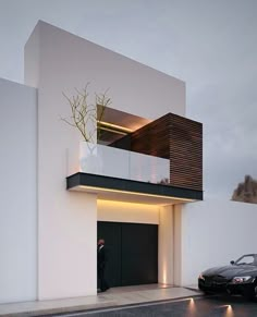 a car parked in front of a white building with a planter on the balcony