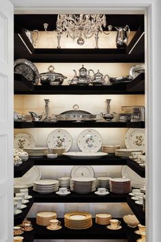 an open cabinet filled with lots of plates and bowls