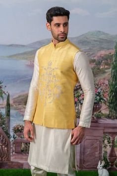 Yellow bundi featuring floral embroidery with zari, pearl, sequin embellishments. Paired with an inner kurta and pant., Fit: Relaxed Festive Bandhgala With Chikankari Embroidery For Designer Wear, Chanderi Nehru Jacket With Zari Work For Eid, Festive Raw Silk Bandhgala With Chikankari Embroidery, Diwali Bandhgala In Chanderi With Zari Work, Eid Raw Silk Nehru Jacket With Chikankari Embroidery, Eid Nehru Jacket In Raw Silk With Chikankari Embroidery, Unstitched Chanderi Bandhgala For Diwali, Festive Unstitched Bandhgala With Chikankari Embroidery, Festive Bandhgala With Chikankari Embroidery