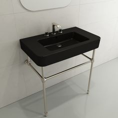 a black sink sitting on top of a metal stand next to a white tiled wall