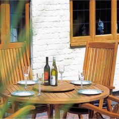 a wooden table and chairs with bottles of wine on it