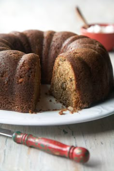 a bundt cake on a plate with one slice cut out and ready to be eaten