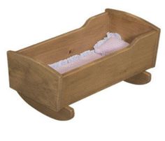 a wooden cradle with pink and white cloths in it