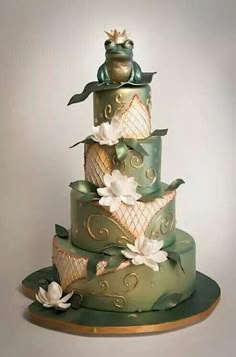 a three tiered green cake with white flowers on it's top and sides