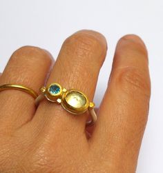 Citrine and Blue Topaz ring- Beautiful Citrine and Blue Topaz ring wrapped with 24 k solid gold decorated with 24 k gold dots . Round sterling silver band 2 mm wide in Matte finish. The Citrine stone size is 7/9 mm. The Blue Topaz stone size is 5 mm. The ring size is 9.5 US /61 U. The ring will be packed in a Beautiful gift box . Free Shipping!! Your item will be shipped via registered air mail with tracking number. Please contact me with any questions or requests. Noga Unique Gold Sapphire Ring With Rose Cut Diamonds, Fusion Style Oval Birthstone Rings, Oval Birthstone Fusion Rings, Unique Yellow Gold Moonstone Open Ring, Gift Yellow Gold Topaz Ring, Unique Yellow Gold Open Moonstone Ring, Yellow Gold Topaz Rings For Gifts, Yellow Gold Sapphire Open Ring In Unique Style, Unique Yellow Gold Rings With Birthstone