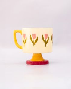 side view of top view of cream 10 oz ceramic mug with yellow handle, pink pedestal base and pink tulip print Thick Mug, Pretty Ceramic Mugs, Ceramic Painted Mug, 60s Ceramics, Cool Ceramics, Funky Pottery, Retro Ceramics, Tulip Mug, Interior Objects