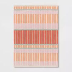 an orange and pink striped wall hanging on a white wall