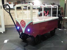 a red and white wagon with lights on it in a kitchen next to a counter