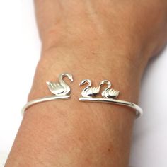 "Silver Mother and Child Swan Bracelet is handmade with its own uniqueness. It can be bought as a gift for any occasion like birthday gift, wedding gift, travel gift, souvenir and etc. If you need rose gold plating or yellow gold plating, please contact us, we will advice you on the additional fees applicable. Base Material: Sterling Silver Size: 15mm (Approximately) Bangle wrist size: Adjustable / Please give us your wrist circumference. Thickness: 1.5mm / 0.059 Inch Metal Stamped: 925 Crafting Cute Handmade Bracelets For Mother's Day, Cute Bangle Jewelry For Birthday, Cute Bangle For Birthday, Handmade Sterling Silver Bracelets As Gift, Cute Birthday Bangle Jewelry, Whimsical Handmade Bracelets For Birthday, Whimsical Handmade Bracelets For Birthdays, Cute Handmade Jewelry For Mother's Day, Handmade Adjustable Whimsical Bracelets