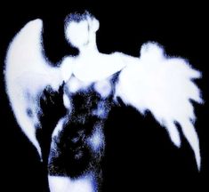 an angel with white wings on a black and white background in the image is blurry