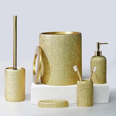 gold bathroom accessories set on white surface