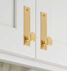 a close up of a door handle on a white cabinet with gold handles and knobs