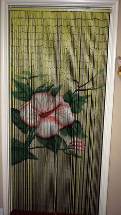 a painting on the side of a door that has bamboo blinds with flowers painted on it