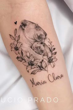 a woman holding her arm with a tattoo on it that reads, mama bear and cub