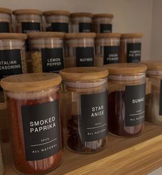 jars filled with spices sitting on top of a wooden shelf