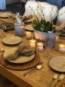 the table is set with dishes, silverware and candles