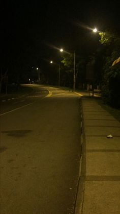 an empty street at night with no cars on it