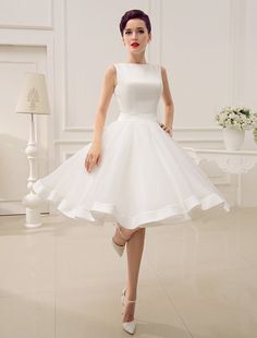 a woman in a white dress is posing for the camera