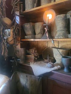 an old fashioned lamp is on top of a shelf in a room filled with buckets and other items