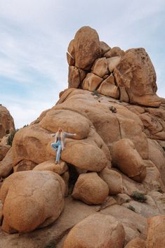 a person sitting on top of a large rock formation