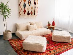 a living room with white furniture and rugs