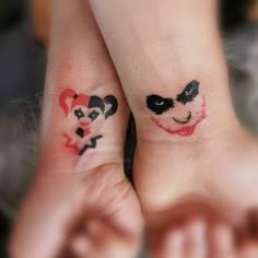 two people with matching tattoos on their feet, one has a heart and the other has a face