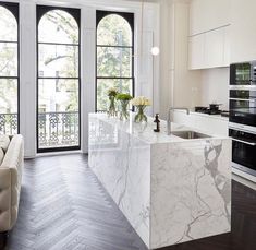 a large kitchen with marble counter tops and an island