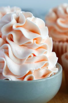 two cupcakes with white frosting in a bowl