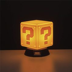 an illuminated lamp with question mark on it's face in the shape of a cube