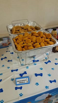 two trays filled with dog treats on top of a blue and white table cloth