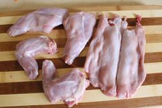 several pieces of raw chicken sitting on a cutting board