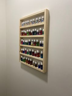 a wall mounted shelf filled with lots of different colored bottles on it's sides