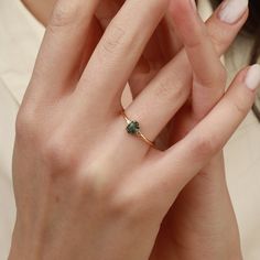 This refined engagement ring features a stunning 4x6 mm hexagon-shaped green sapphire as its centerpiece, symbolizing tranquility and uniqueness. The sapphire is flanked by a single sparkling diamond on each side, adding a subtle yet elegant touch. The diamonds, totaling 0.06 carats, enhance the brilliance of the green sapphire, making this ring a beautiful and modern choice for an engagement. Material: 14-karat solid gold Gold Colors: Available in yellow, rose, or white gold Center Stone: 4x6 mm hexagon-cut green sapphire Accent Stones: 2 round diamonds, 0.06 carats total, G VS clarity Band Width: 1.5 mm for a sleek and comfortable fit Style: A contemporary engagement ring with a minimalist design This ring is perfect for those who appreciate simplicity and elegance, offering a distinctiv Emerald Ring With Single Diamond For Anniversary, Minimalist Emerald Ring For Promise, May Birthstone, Minimalist Emerald Cut Emerald Ring, Dainty Emerald Cut Solitaire Birthstone Ring, Fine Jewelry Sapphire Ring For Promise, May Birthstone, Emerald Ring With Single Diamond Gift, Gift Emerald Cut Ring With Single Diamond, Fine Jewelry Sapphire Ring, Emerald Cut, May Birthstone, Fine Jewelry Sapphire Ring Emerald Cut For May Birthstone