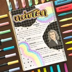 a notebook with the name newton on it surrounded by crayons and marker pens