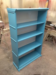 a blue book shelf sitting in the middle of a room