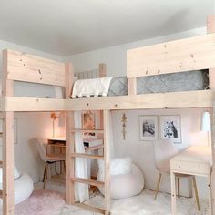 a bedroom with bunk beds and desks in it