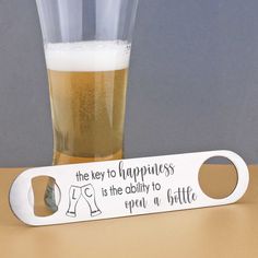 a bottle opener sitting next to a glass filled with beer