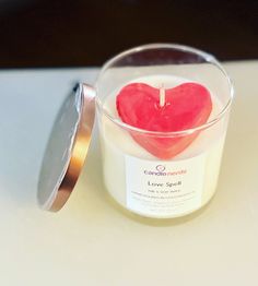 a heart shaped candle in a glass container