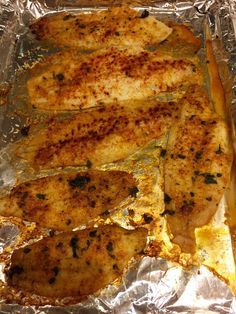 some chicken is sitting on tin foil and ready to be cooked in the oven,